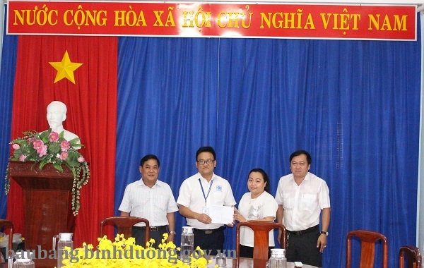 Chủ hộ kinh doanh cá thể bà Trần Thị Trà My trao số tiền cho BCĐ phòng chống COVID-9 của huyện Bàu Bàng.