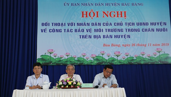 Ông Lê Khắc Tri (ngồi giữa) tại buổi đối thoại với các hộ chăn nuôi về vấn đề môi trường.