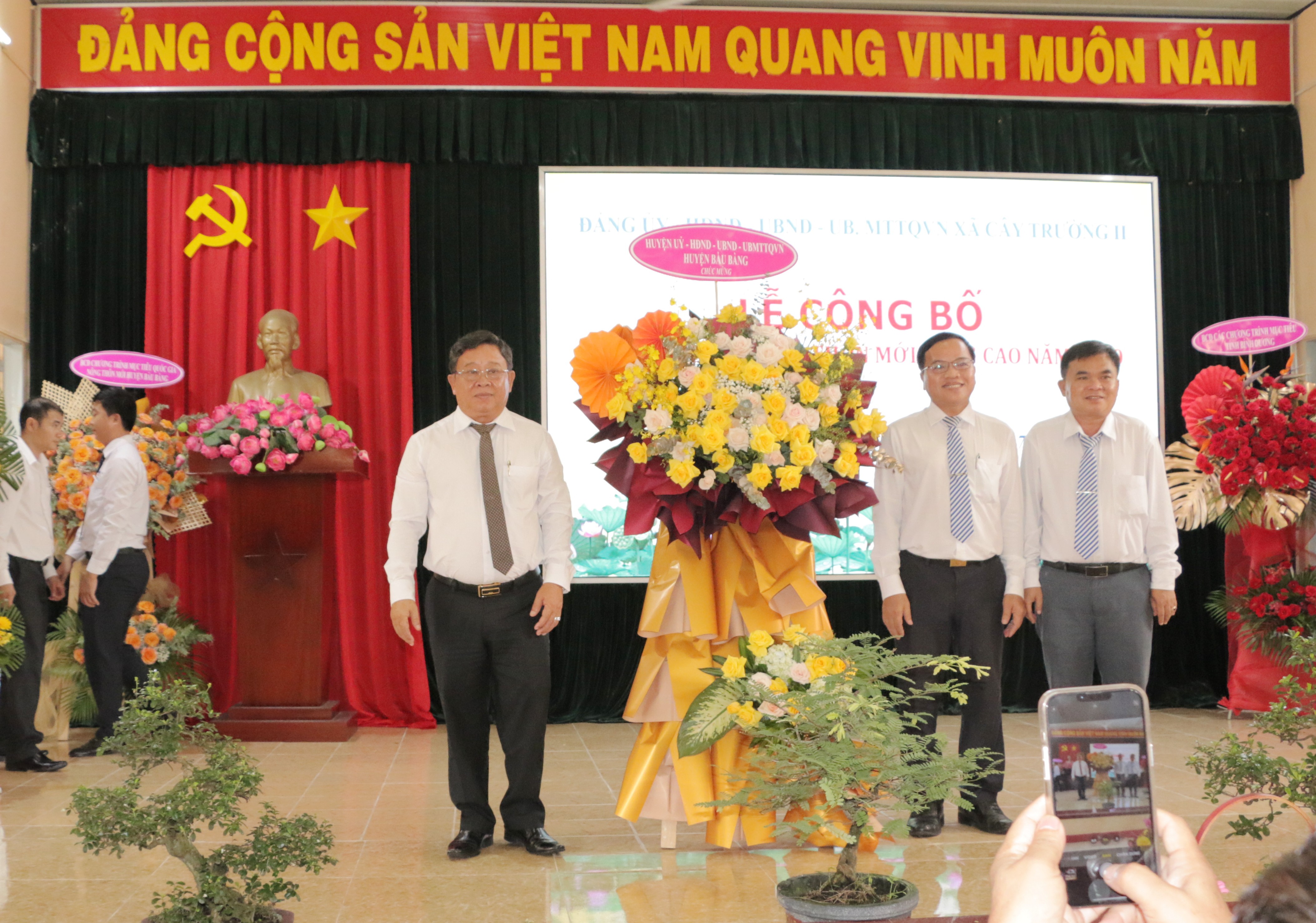Ông Nguyễn Thanh Khiêm - Bí thư Huyện ủy tặng hoa chúc mừng xã Cây Trường II đạt chẩn xã NTM nâng cao.