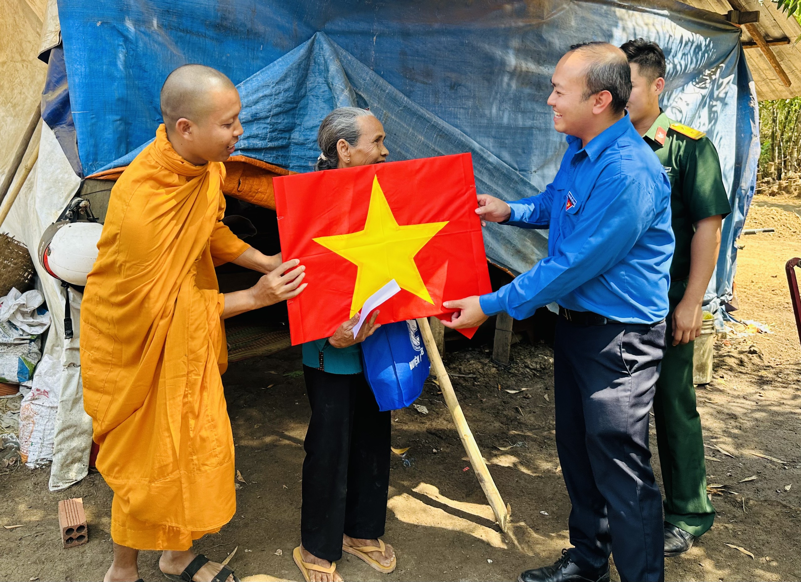 Đồng chí Nguyễn Huỳnh Nguyên Vỹ - Bí thư Huyện Đoàn trao tặng cờ Tổ quốc cho một đồng bào dân tộc Khmer.