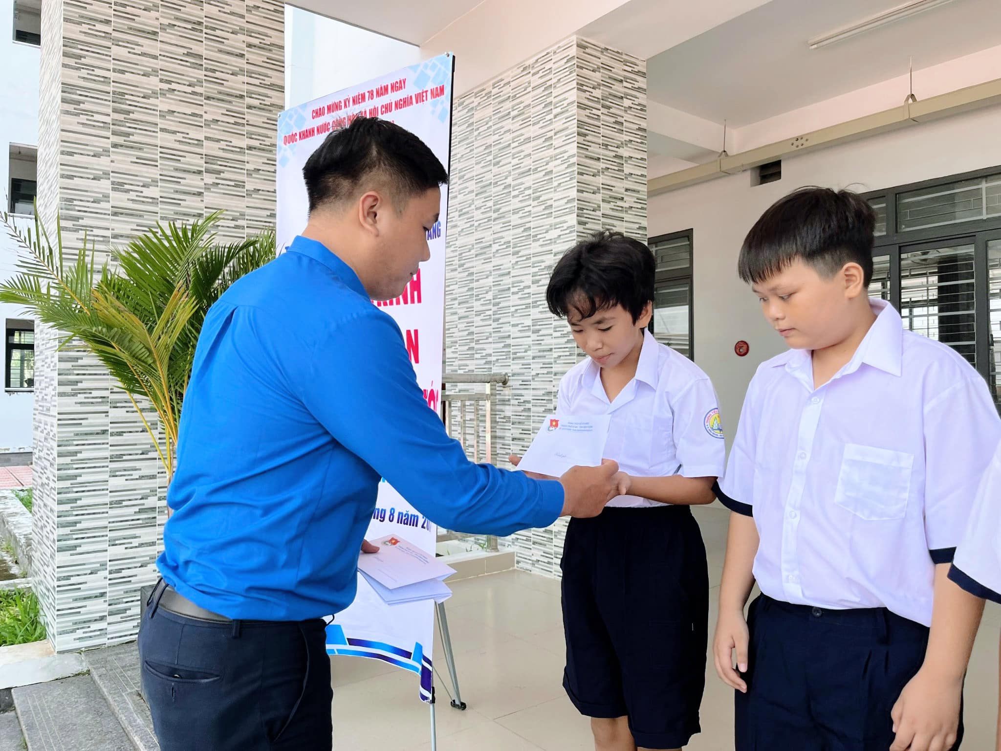 Đồng chí Võ Cao Trí - Phó Bí thư Thành Đoàn Dĩ An trao tặng quà cho các em học sinh.